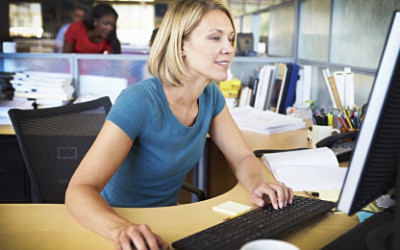 Woman Working At Computer In Modern Office